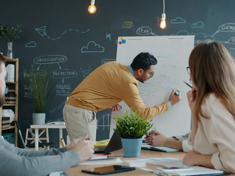 Colleague sketching ideas on a whiteboard during a team session